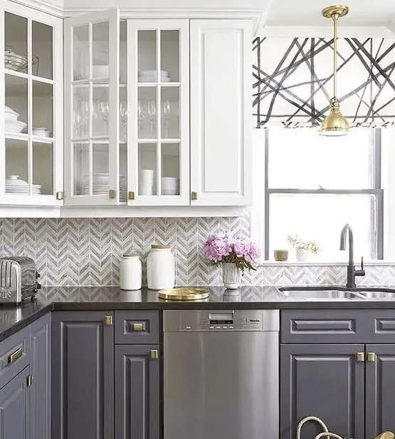 a bold kitchen with a grey and white chevron tile backsplash and a geo roman shade