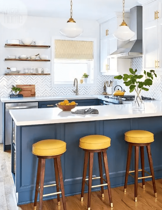 a bright kitchen with navy cabinets, white countertops and a chevron backsplash plus touches of brass and gold