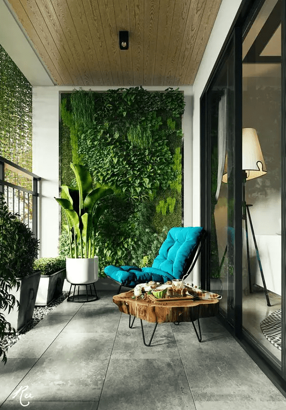 a modern and inviting balcony with a living wall, potted greenery, a wood slice coffee table and a teal lounger is a lovely space to be