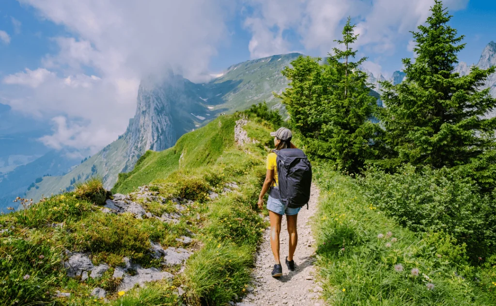 A woman with a backpack stands on top of a mountain, mountain ridge at Saxer Lucke