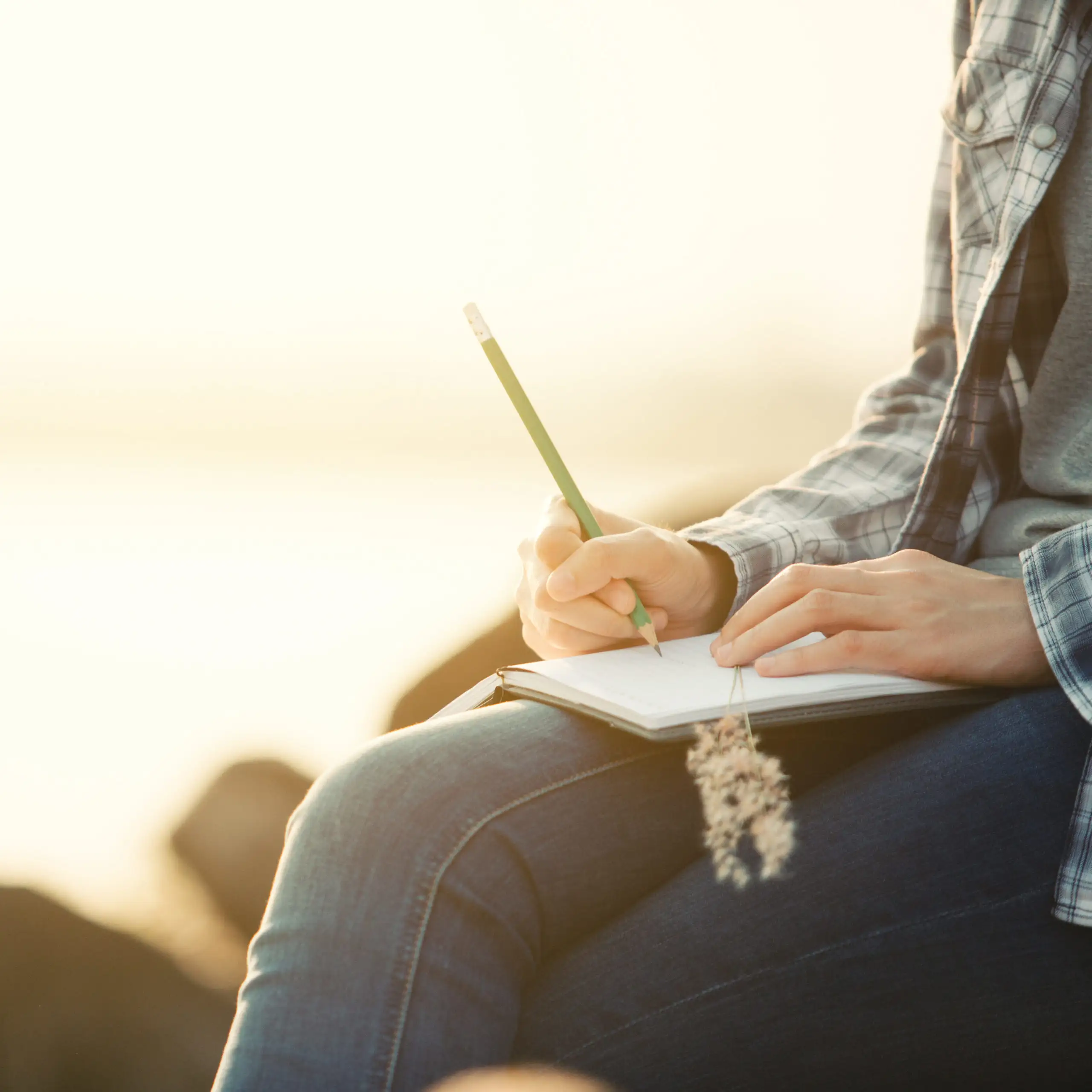 Close up of person writing in a leather journal