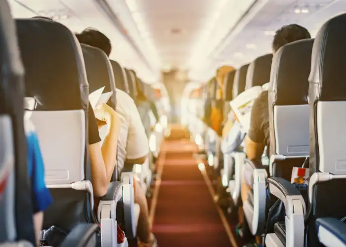 View down the center aisle of an airplane full of passengers