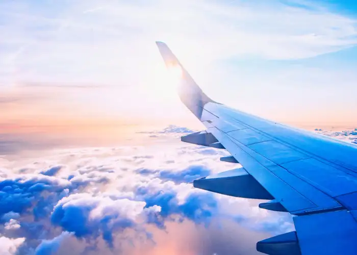 Airplane wing against a sunset sky