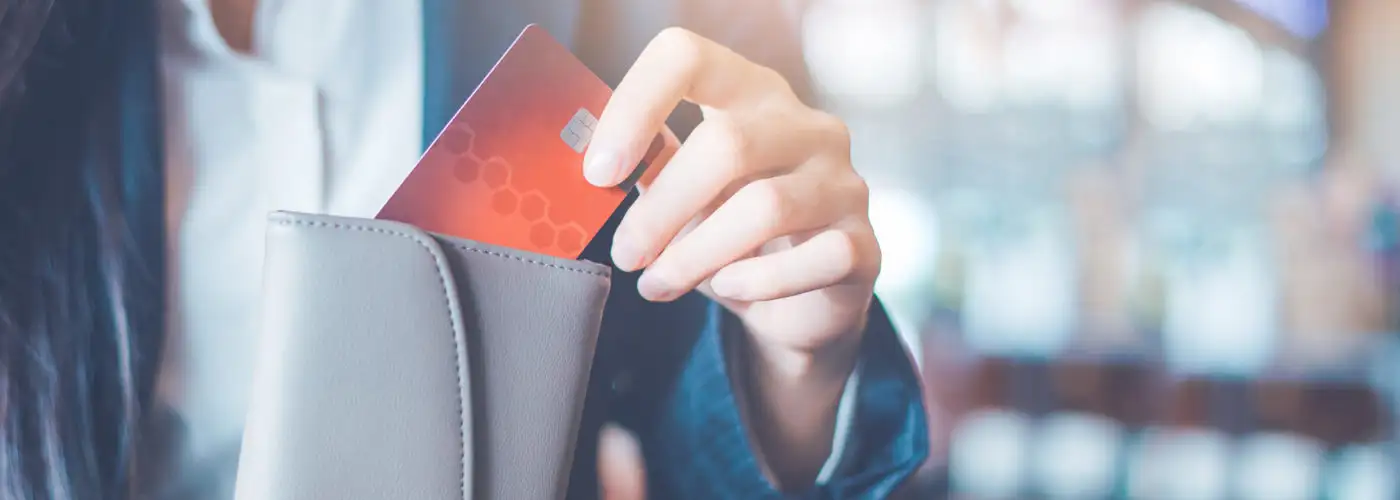 Close up of woman putting a credit card in her wallet