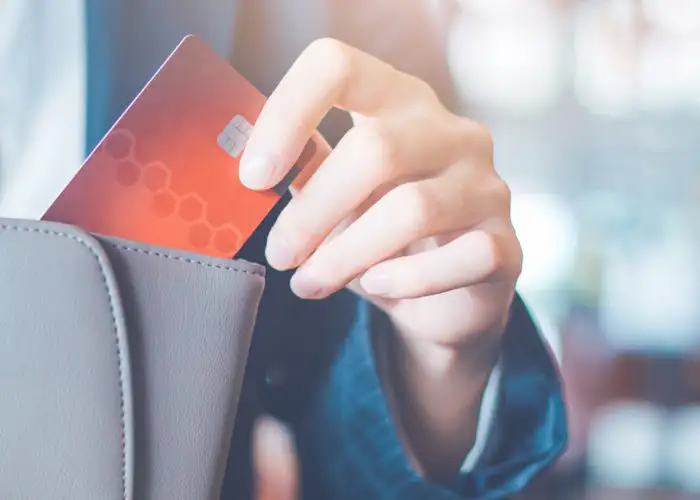 Close up of woman putting a credit card in her wallet