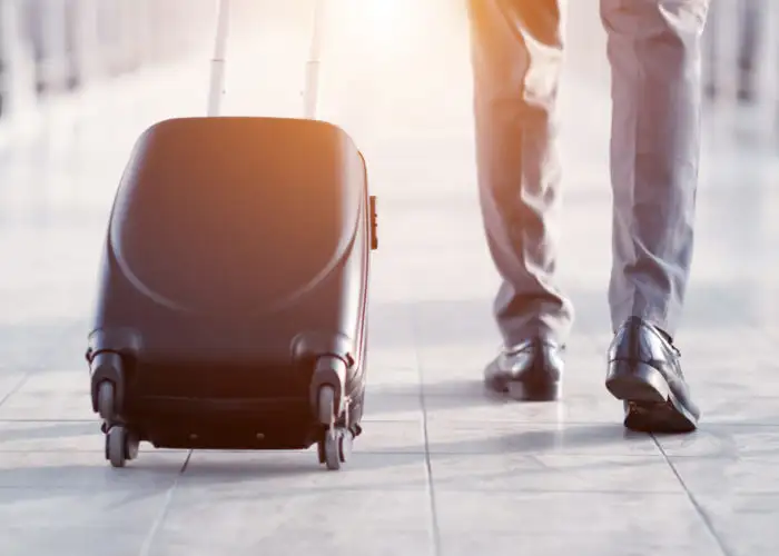 Close up of business man rolling his suitcase down a jetbridge