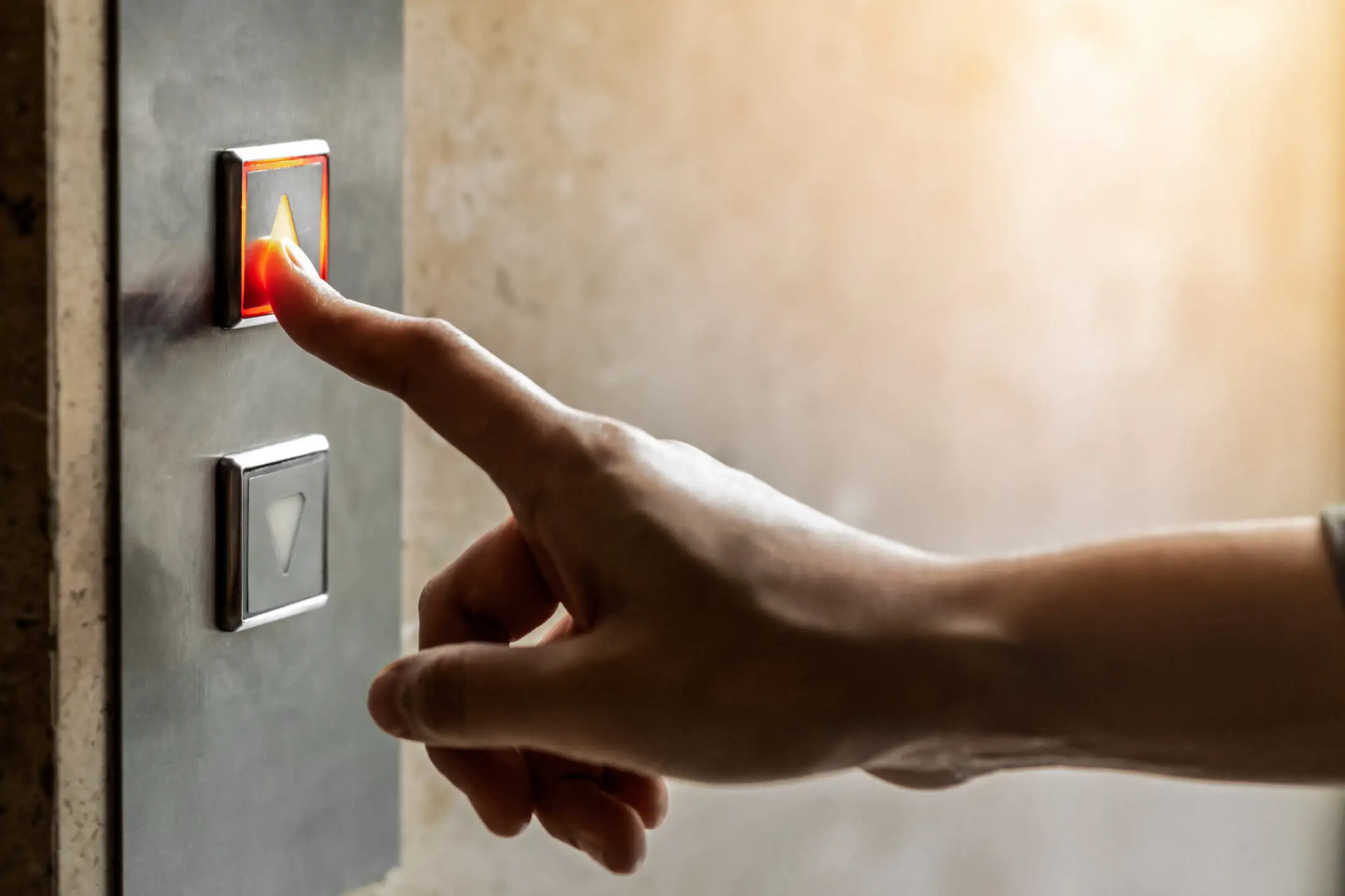 Close up of hand pressing the ascending elevator button