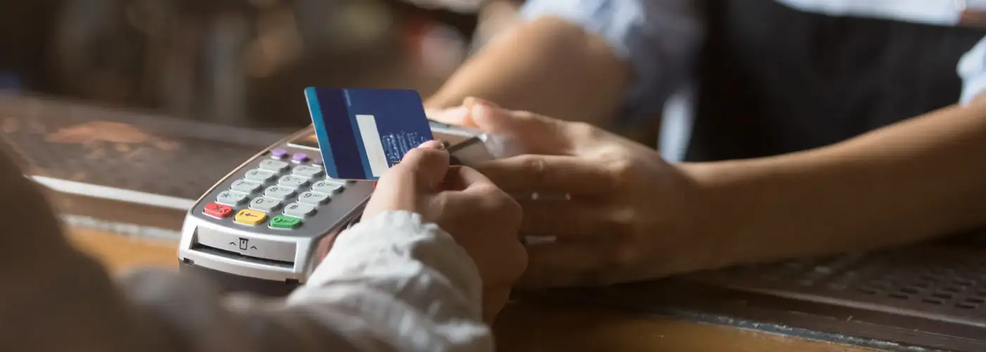 Close up of person paying for purchase using credit card