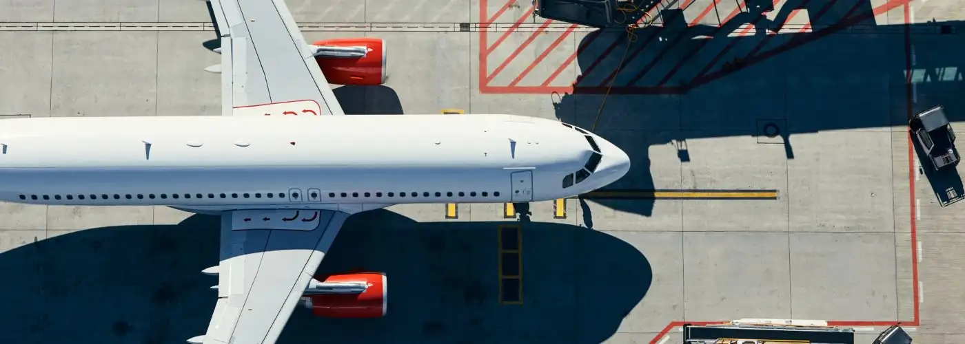 Aerial view of plane on runway pulling into a terminal