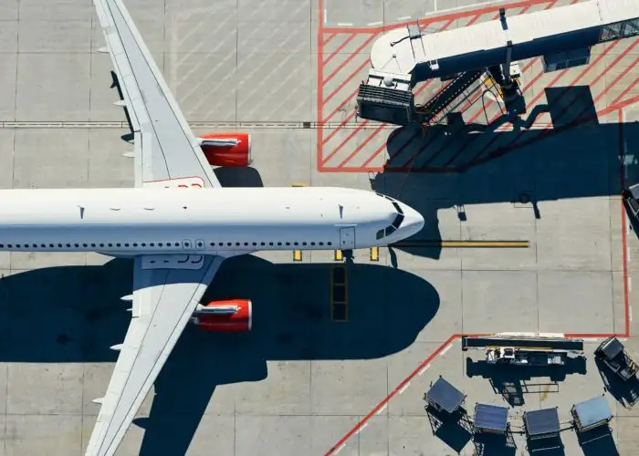 Aerial view of plane on runway pulling into a terminal