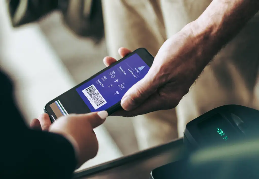 Person scanning digital boarding pass at airport