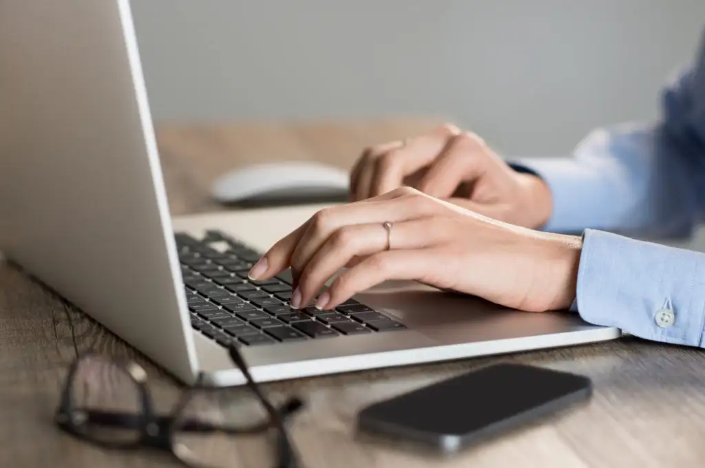 Close up of hands typing on laptop