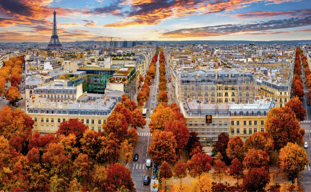 Aerial view of Paris in late autumn at sunset.Red and orange colored street trees. Eiffel Tower in the background. Paris, France