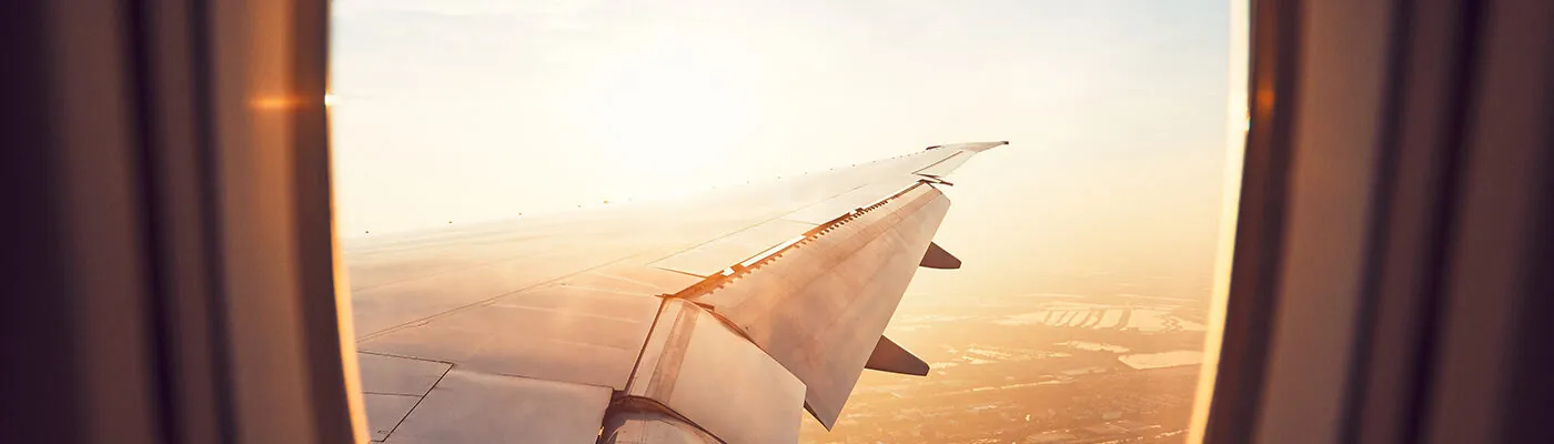 View of wing from airplane window at sunset