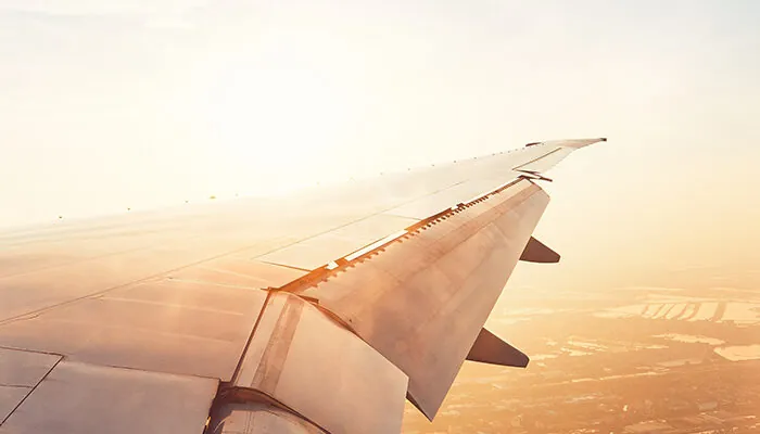 View of wing from airplane window at sunset