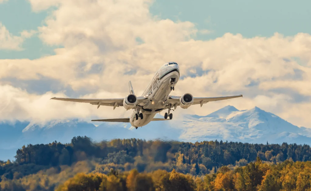 Alaska Airlines jet is taking off from Ted Stevens Anchorage International with high speed jet exhaust distorting the background view