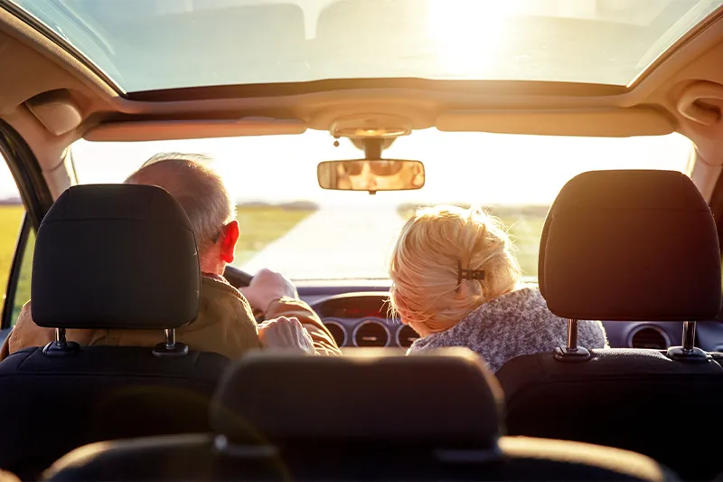 Elderly couple driving rental car