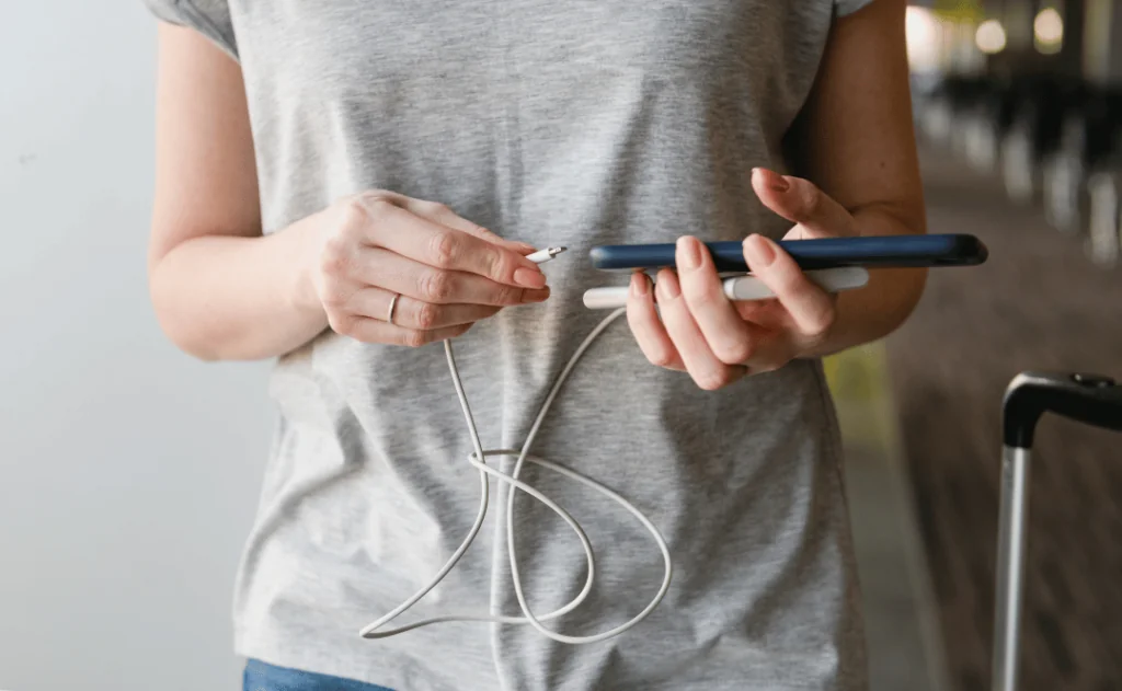 Female hands connect power bank and smartphone