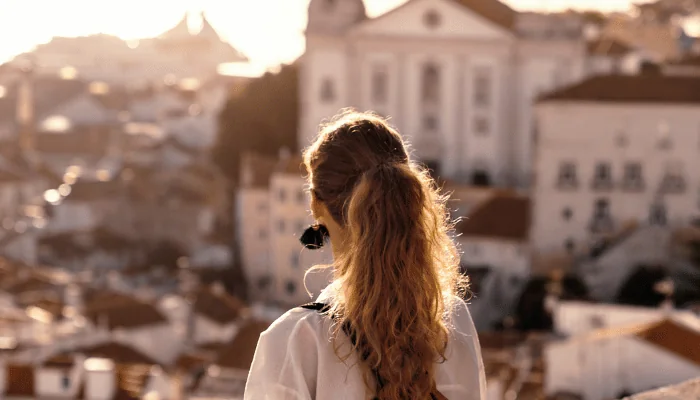 Female tourist looking at old town from balcony