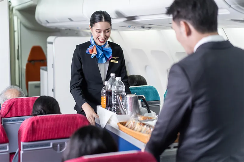 Two flight attendants serving drinks