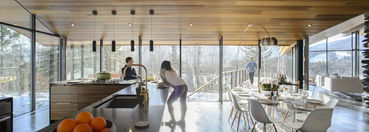 People relaxing in the kitchen of The Stowe Glass House in Stowe Vermont