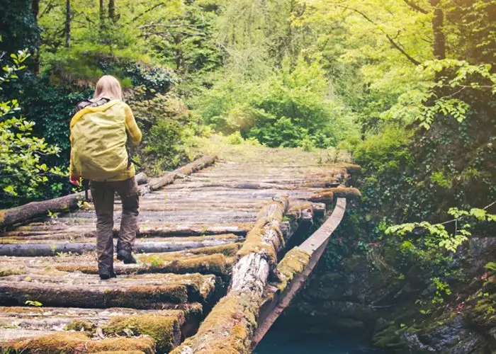 woman hiking on bridge