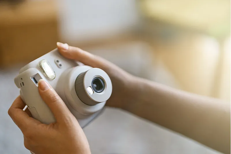 Close up of hands holding an instant print camera