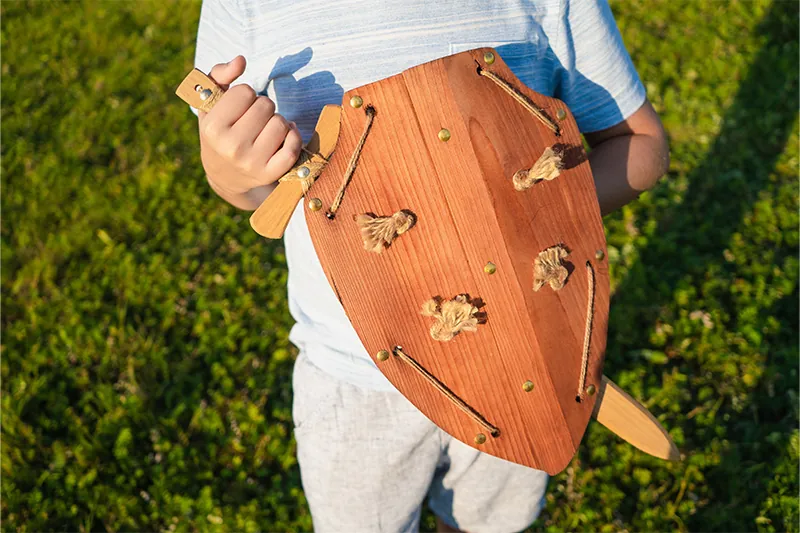 Child playing with toy sword and shield