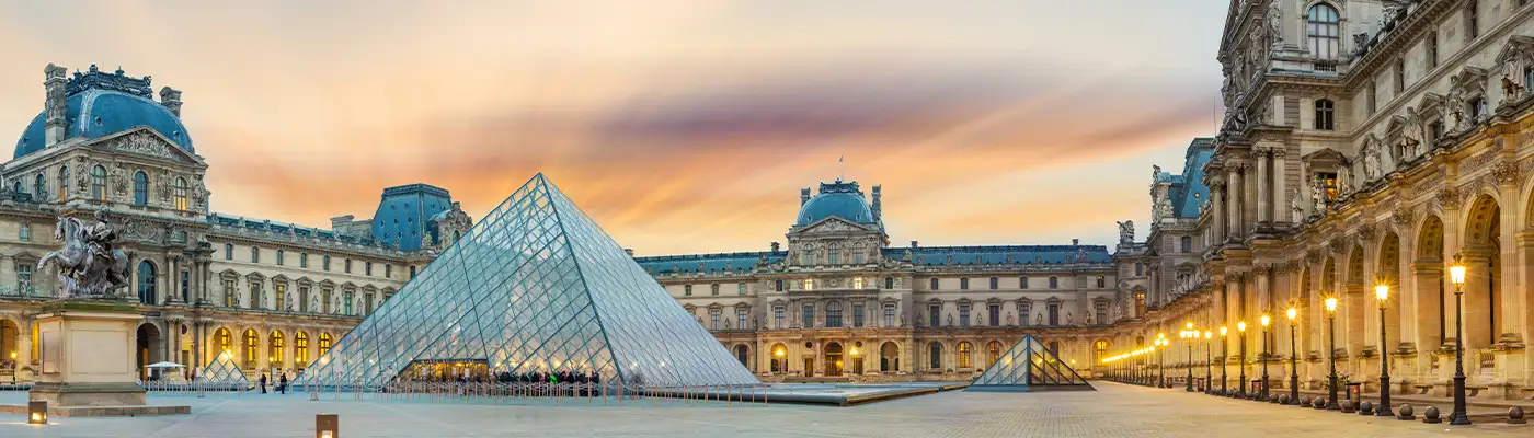 View of famous Louvre Museum with Louvre Pyramid at evening at sunset in Paris France