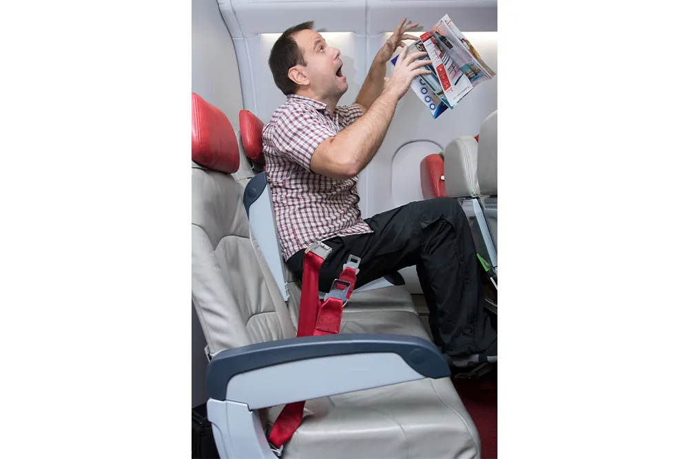 Shocked unfastened man on the plane during turbulence levitates. Accident passenger who is not fasten to the seat.