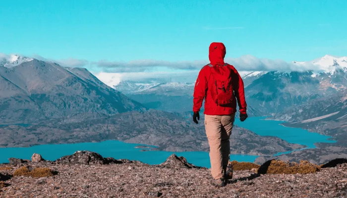 Man in Red Jacket at scenic outlook while Hiking in Patagonia