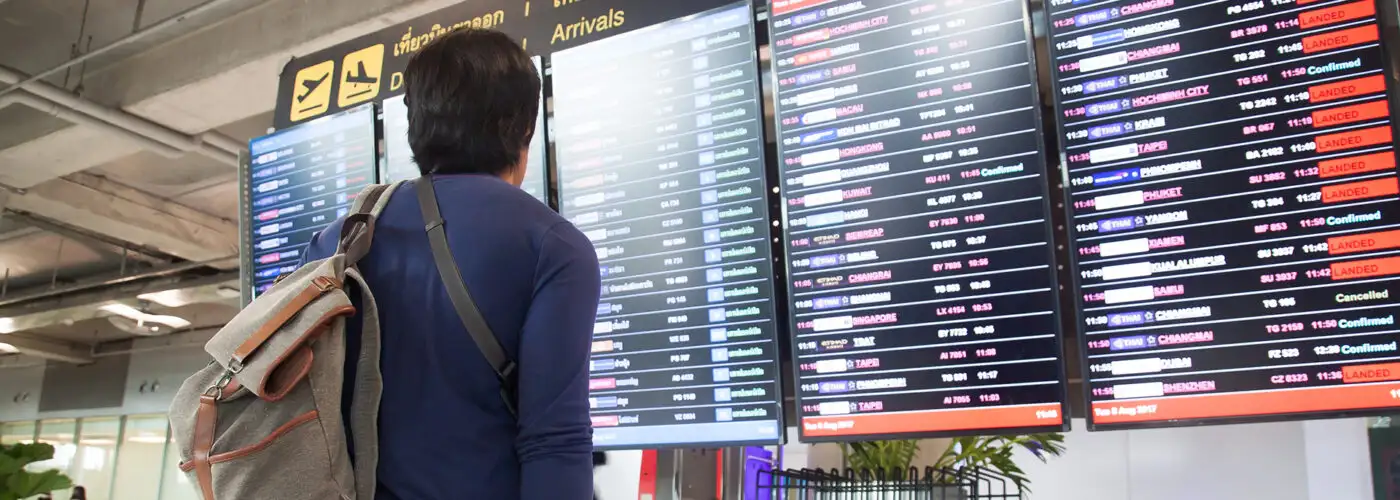 man looking at airport screens.