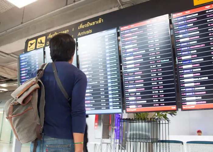 man looking at airport screens.