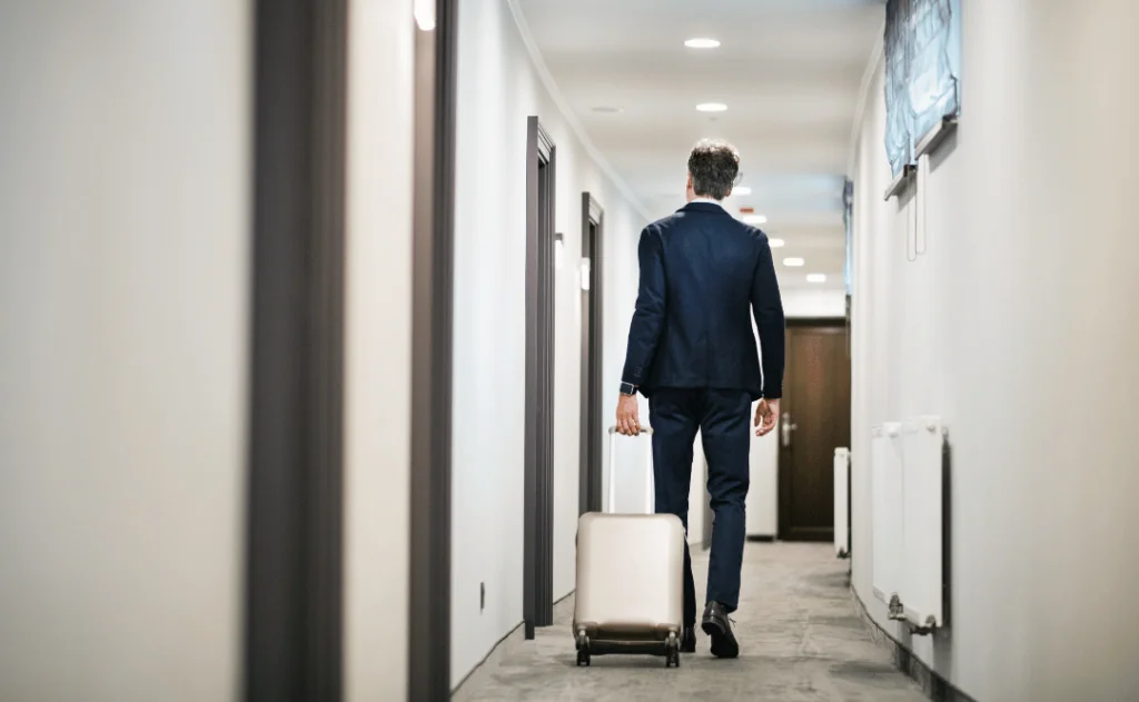 Businessman walking with luggage in a hotel corridor