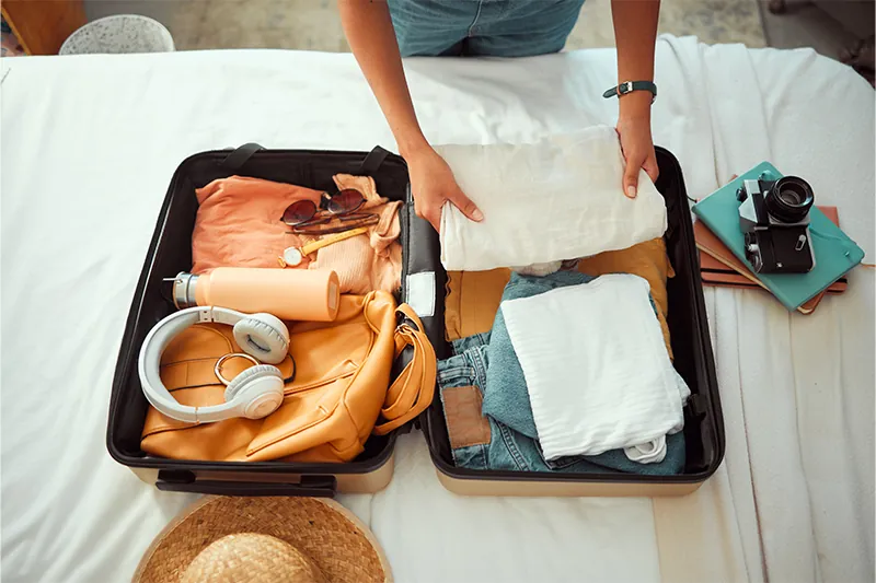 Aerial view of person packing a suitcase