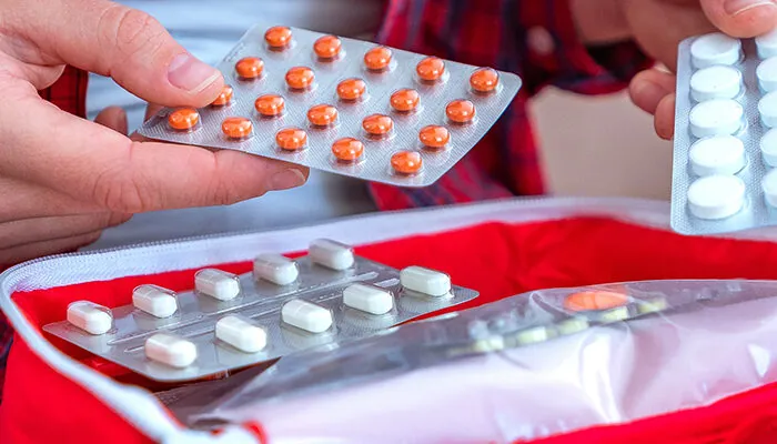 Person packing medication for travel