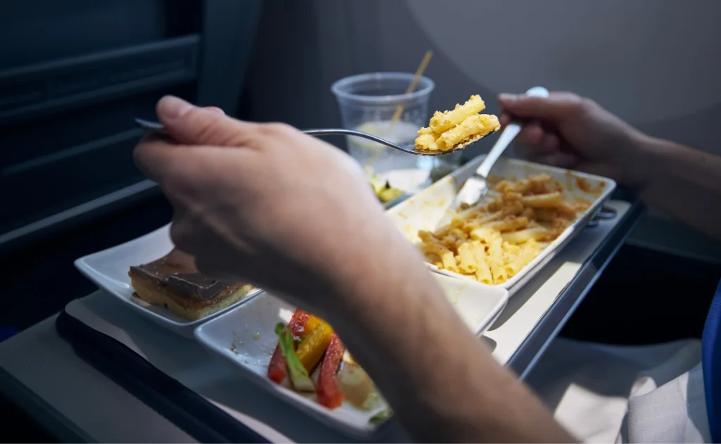 Passenger eating airline meal with metal cutlery.