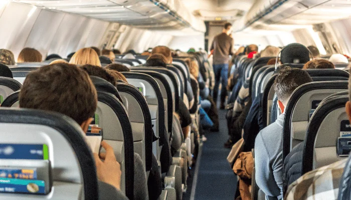 Passengers seated inside of a commercial passenger airplane. Travelers going across the globe.