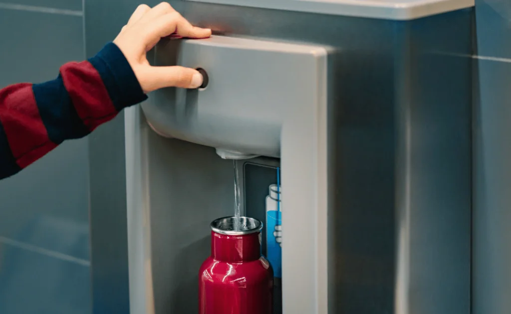 Refilling water bottle at water filling station in the Airport