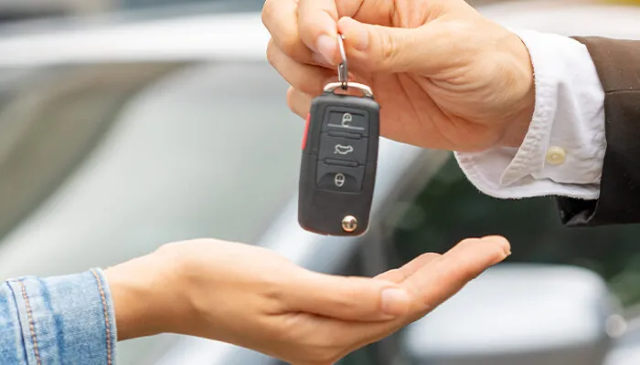 Person handing over the keys to a car rental