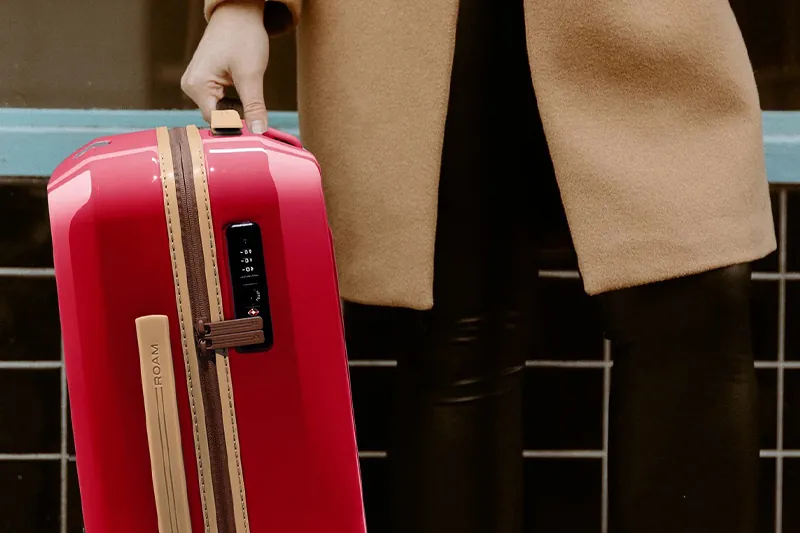 Woman holding a customized suitcase from ROAM