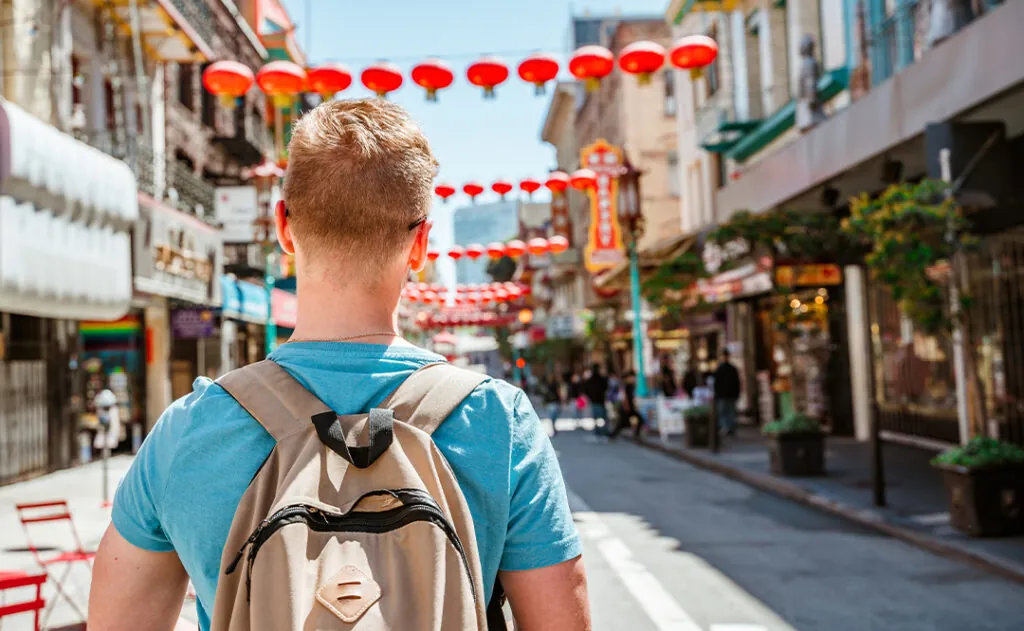 Rear view of a young man walking through Chinatown in downtown San Francisco. San Francisco, USA - 18 Apr 2021