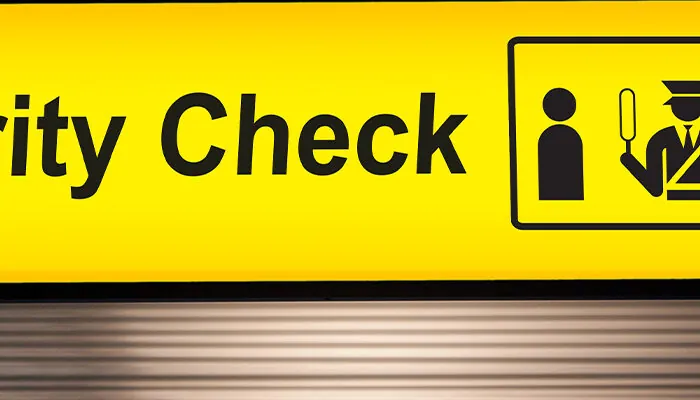 security check sign hanging from airport terminal ceiling