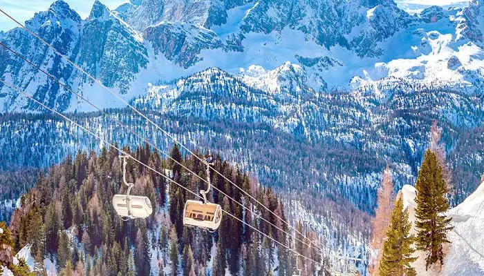 Two chairs on a ski lift in the Dolomites, Italy on a clear day