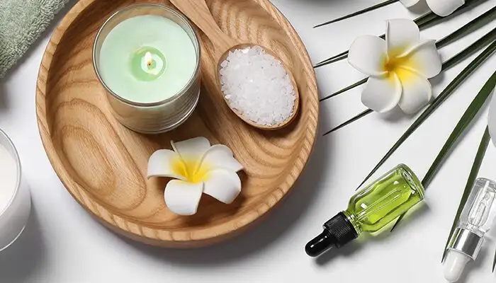 Table laid out with candles, flowers, and other wellness accessories, as seen from above