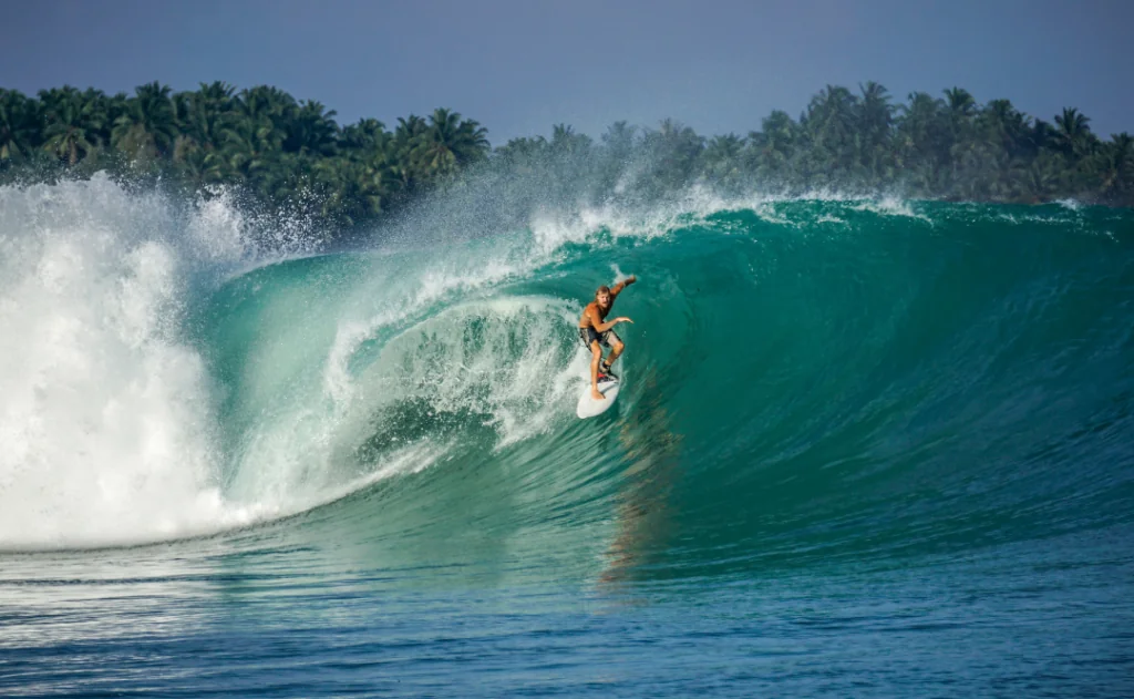 Surfer on perfect blue big tube wave, empty line up, perfect for surfing, clean water, Indian Ocean in Mentawai islands