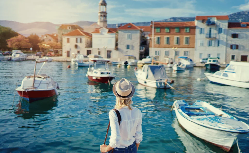 TYoung traveling woman enjoying the view of Kastel Castle walking near the sea on Croatian coast