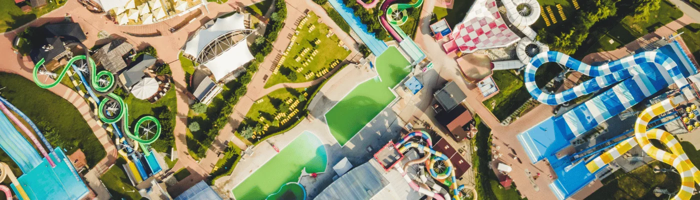 Colourful plastic slides in aquapark. Sliders with pool. Enjoying summer vacation in water park. Aerial view of aqua park.