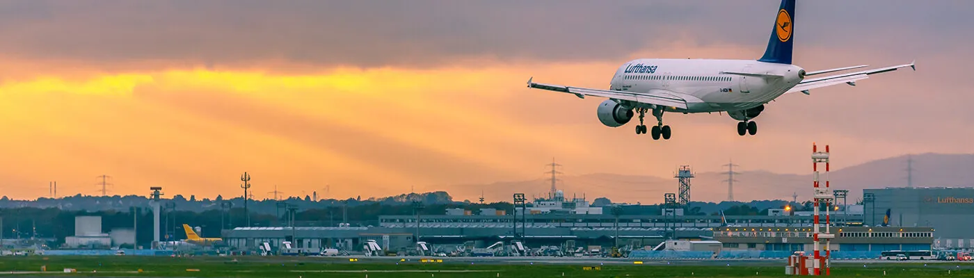 lufthansa airplane landing at sunset