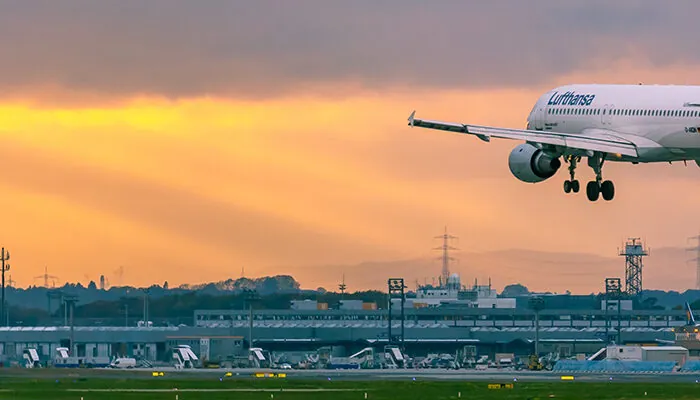 lufthansa airplane landing at sunset